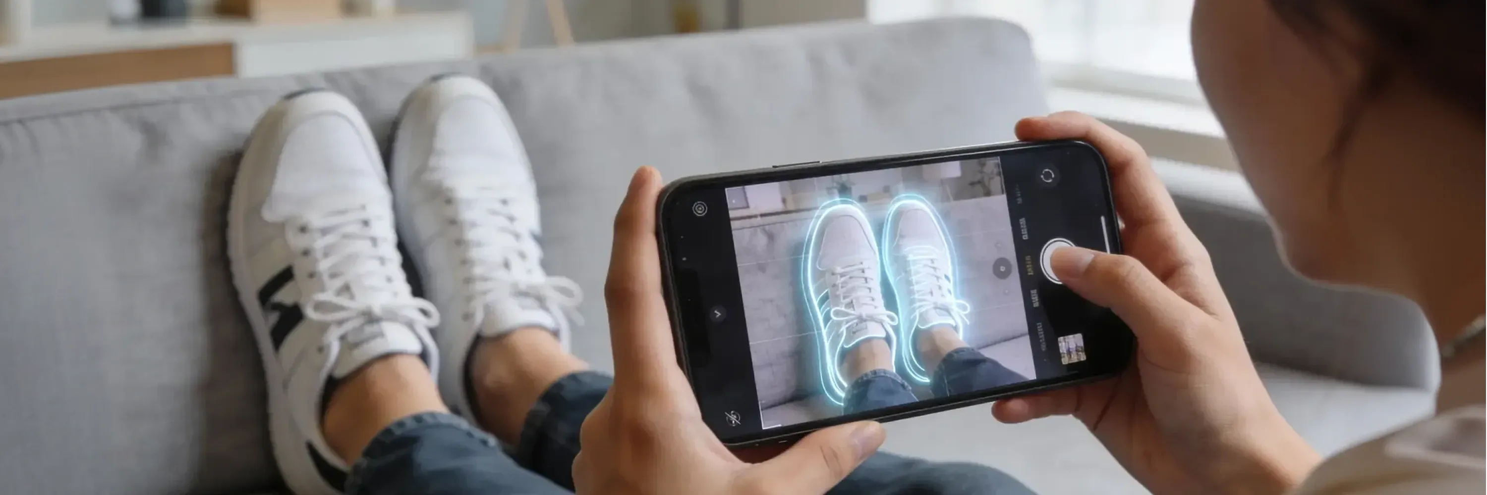 Person using a smartphone to scan their shoes with AI-powered augmented reality, visualizing digital overlays for product recognition and fit analysis